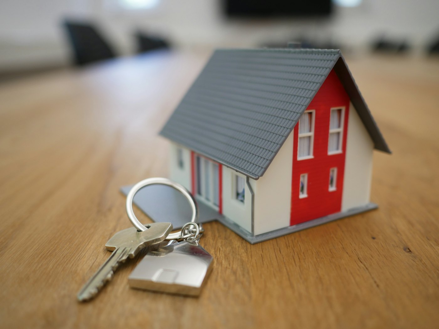 Stock photograph of house keys beside a small model house, used to illustrate the about section.